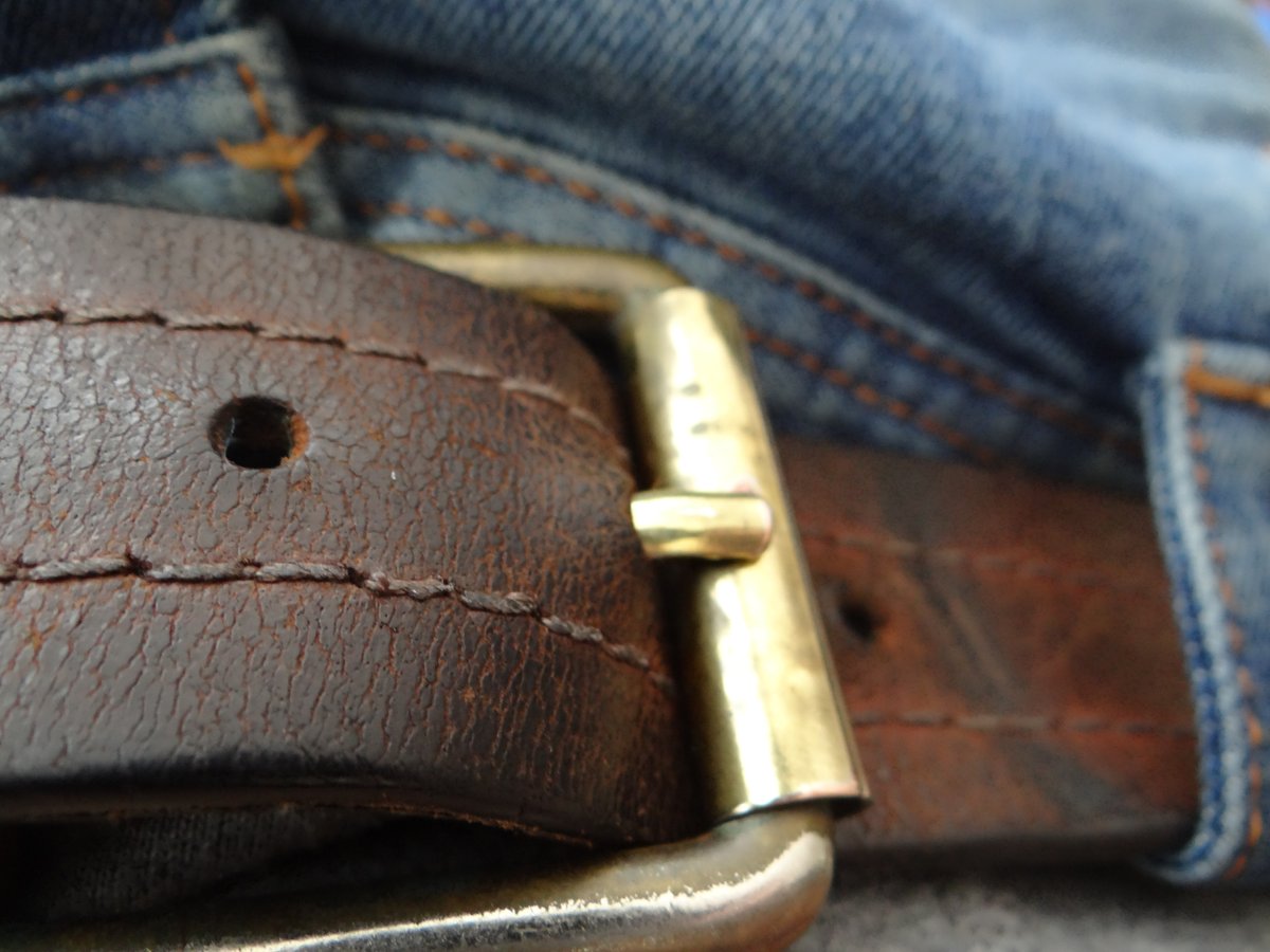 Denim and leather belt buckle detail